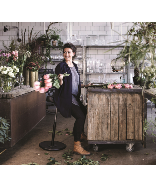 Frau auf Sitzhocker Varier Move in einem Blumenladen